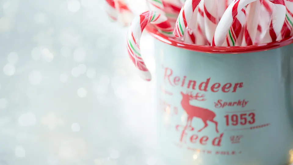 Bastones de caramelo rojos y blancos en una taza pequeña