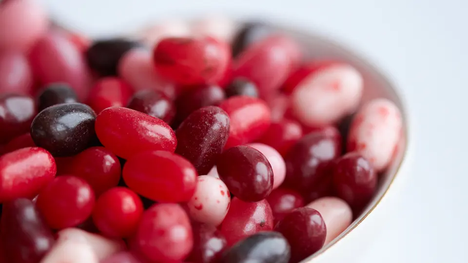 Un cuenco con caramelos rojos, blancos y oscuros